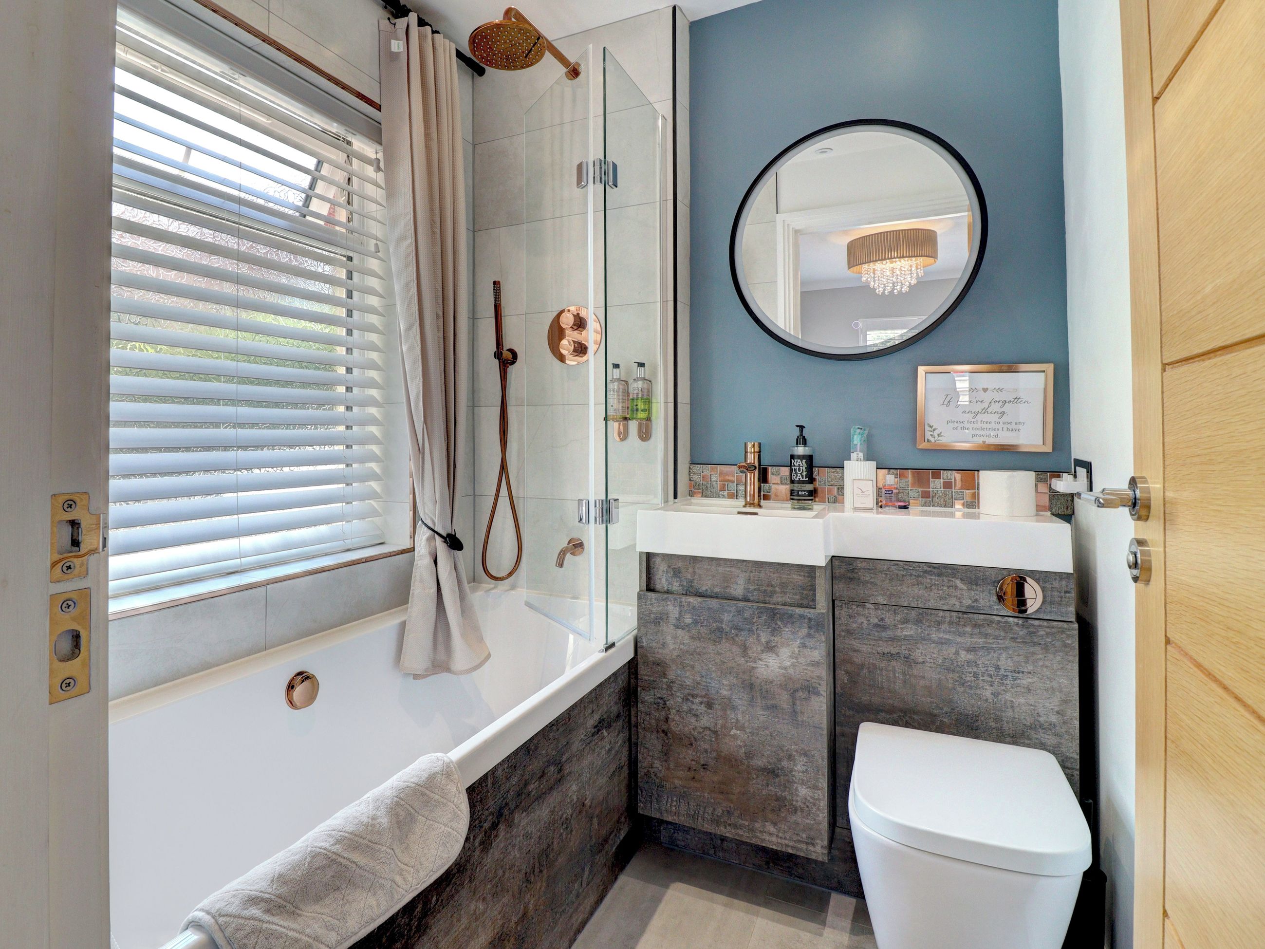 A modern bathroom with a bathtub, shower, and toilet.