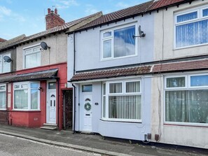 A row of terraced houses with white-framed windows and satellite dishes. - 2 bedroom accommodation in Guisborough (Guisborough)