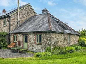 A stone house with a sloped roof and a small porch. - Verbena Cottage - UK52179 (Beaworthy)