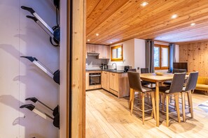 Une cuisine moderne avec des meubles en bois, un îlot central et un coin repas comprenant une table et des chaises.