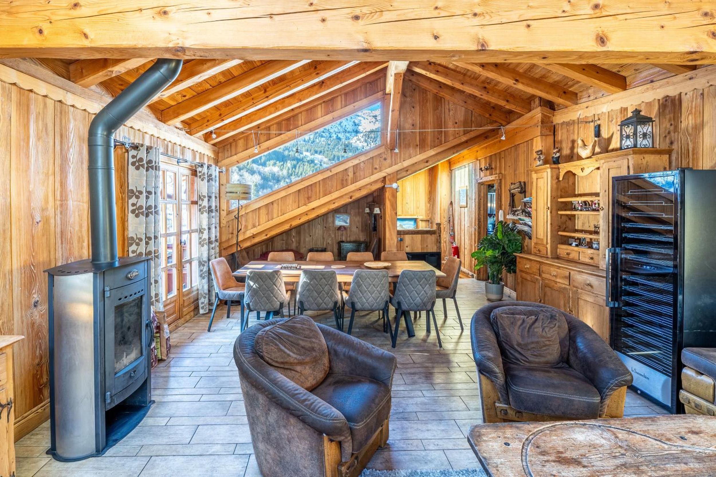 Un intérieur en bois comprenant un coin repas, des sièges et un poêle à bois encastré.