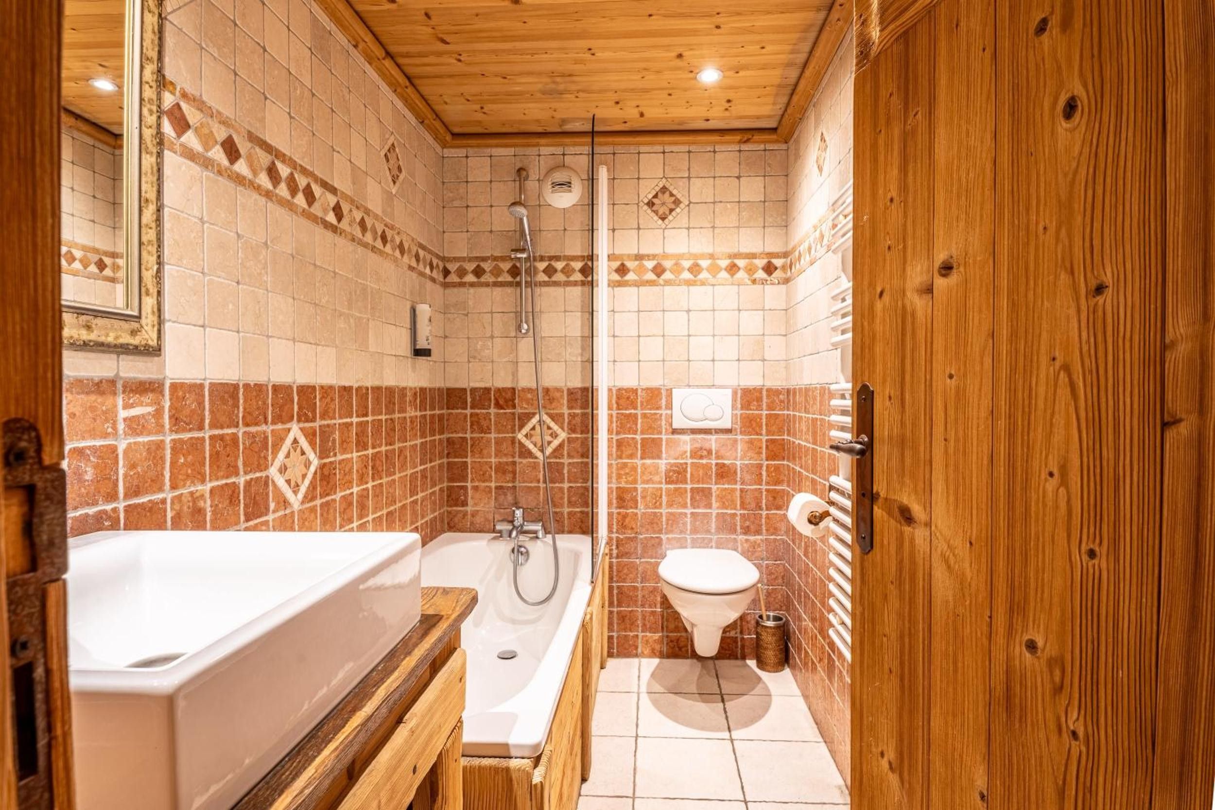 A bathroom with a bathtub, shower, and toilet.