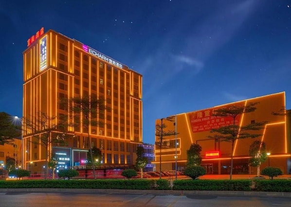 A multi-story hotel with illuminated signage and a modern facade. - Echarm Hotel Foshan West Station Shishan Luocun (Foshan)