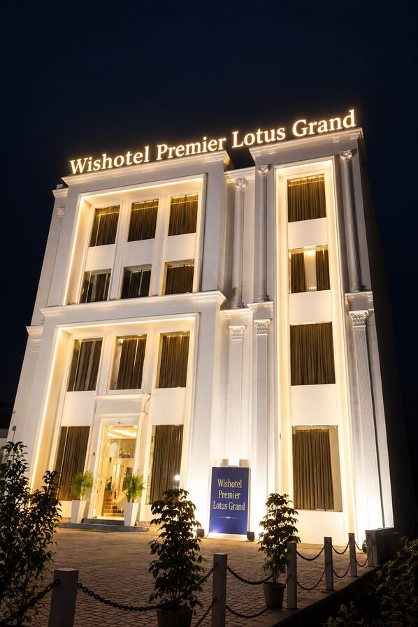 A hotel building with a sign reading 'Wishotel Premier Lotus Grand.'