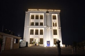 A hotel with a grand entrance, large windows, and a prominent sign.