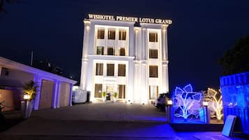 Un hôtel doté d’une entrée imposante et d’une enseigne indiquant : « WISHOTEL PREMIER LOTUS GRAND ».