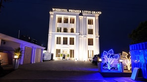 Un hôtel doté d’une entrée imposante et d’une enseigne indiquant : « WISHOTEL PREMIER LOTUS GRAND ».