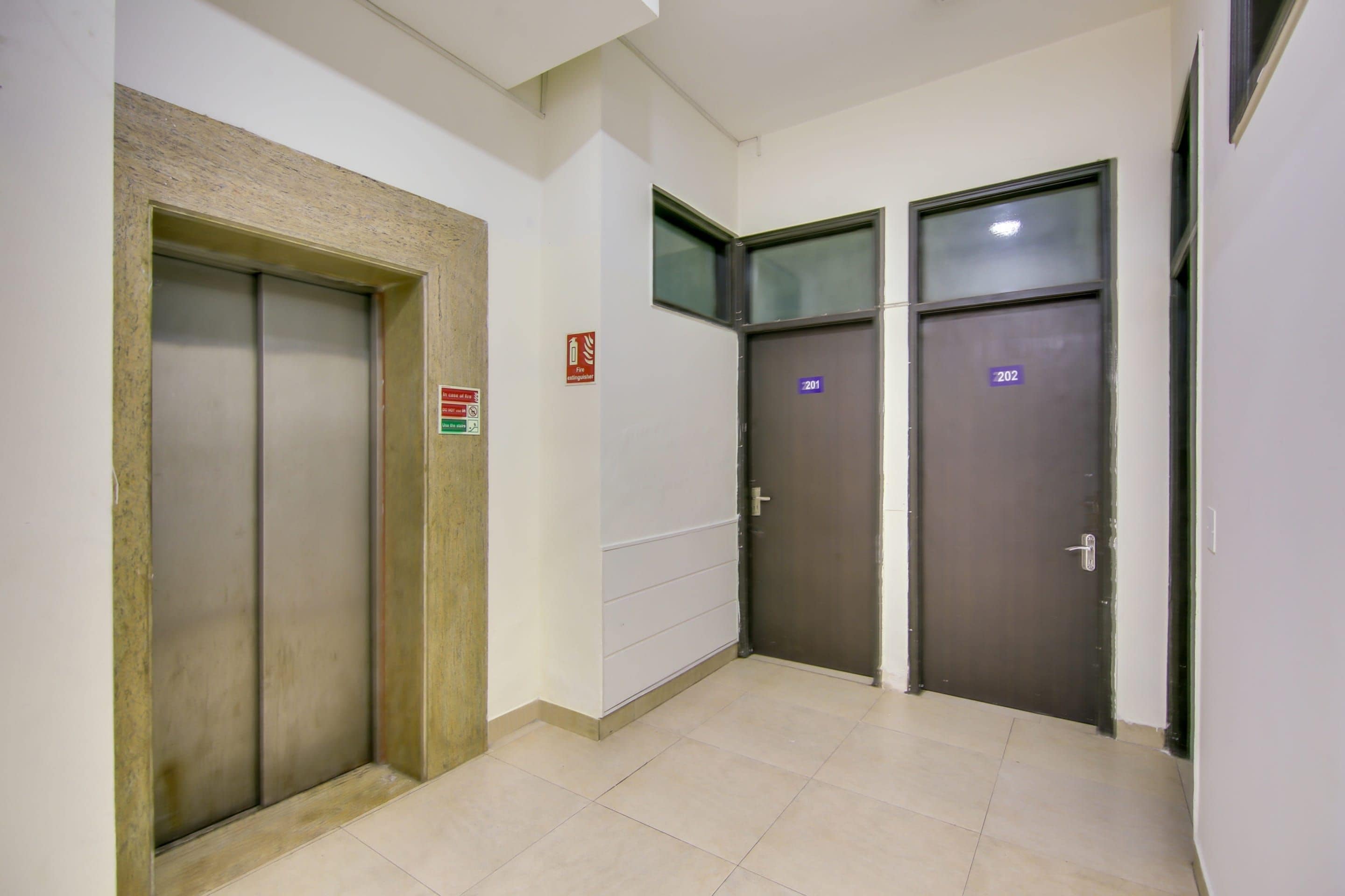Un pasillo con dos puertas, una señalizada con un rótulo de extintor y la otra con un número.