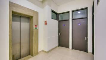 Un pasillo con dos puertas, una señalizada con un rótulo de extintor y la otra con un número.