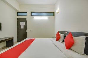 A hotel room with a bed, a desk, a wardrobe, and a television. - Hotel O Dream View (Gurgaon)