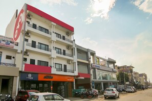 A multi-story building with commercial establishments on the ground floor, including a Suzuki dealership and a service center. - Hotel O Dream View (Gurgaon)