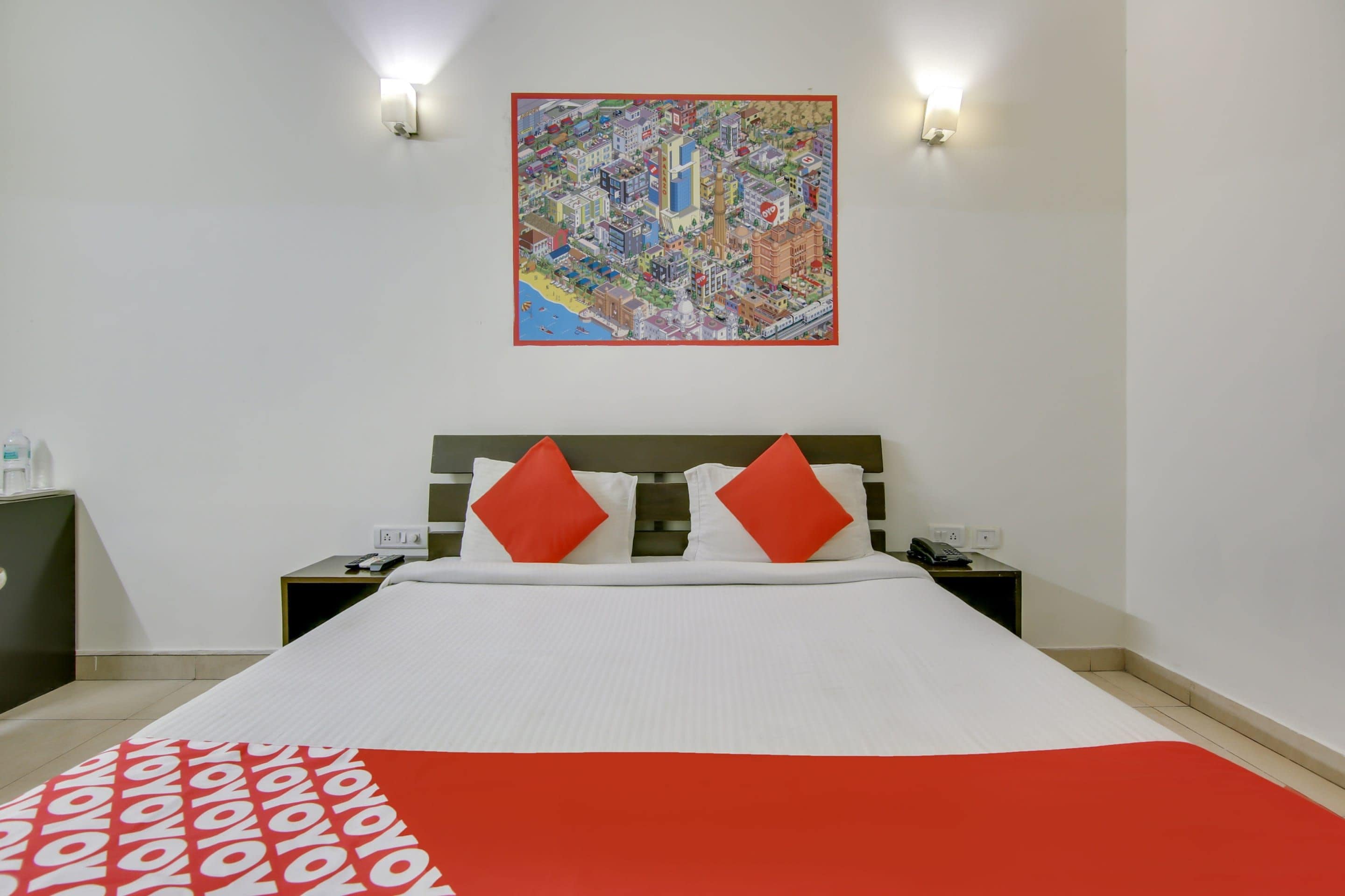 A hotel room with a bed, two nightstands, a telephone, and a wall-mounted artwork.