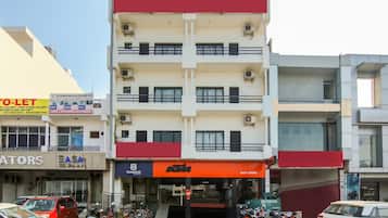 Un edificio de varios pisos con locales comerciales en la planta baja, incluyendo una tienda de motocicletas y un banco.