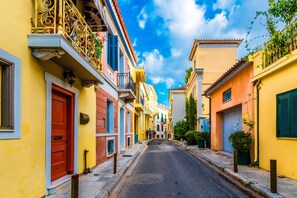 A narrow street lined with colorful buildings, a red door, and a clear blue sky. - Hospitality Expert - Pefki Prestige Condo (Pefki)