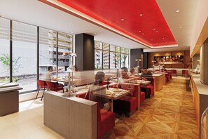 Un restaurant moderne aux accents rouges, doté de grandes fenêtres et offrant une vue sur la ville.