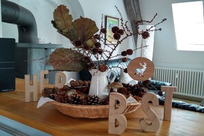 A room with a wooden table displaying a decorative arrangement with letters 'H', 'E', 'R', 'B', 'S', 'T' and a wooden deer figurine. - Modernity meets history (Lübeck)