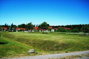 A grassy field with a gravel path and a white car parked on the side. - Holiday apartment with 2 bedrooms (Bakenberg)