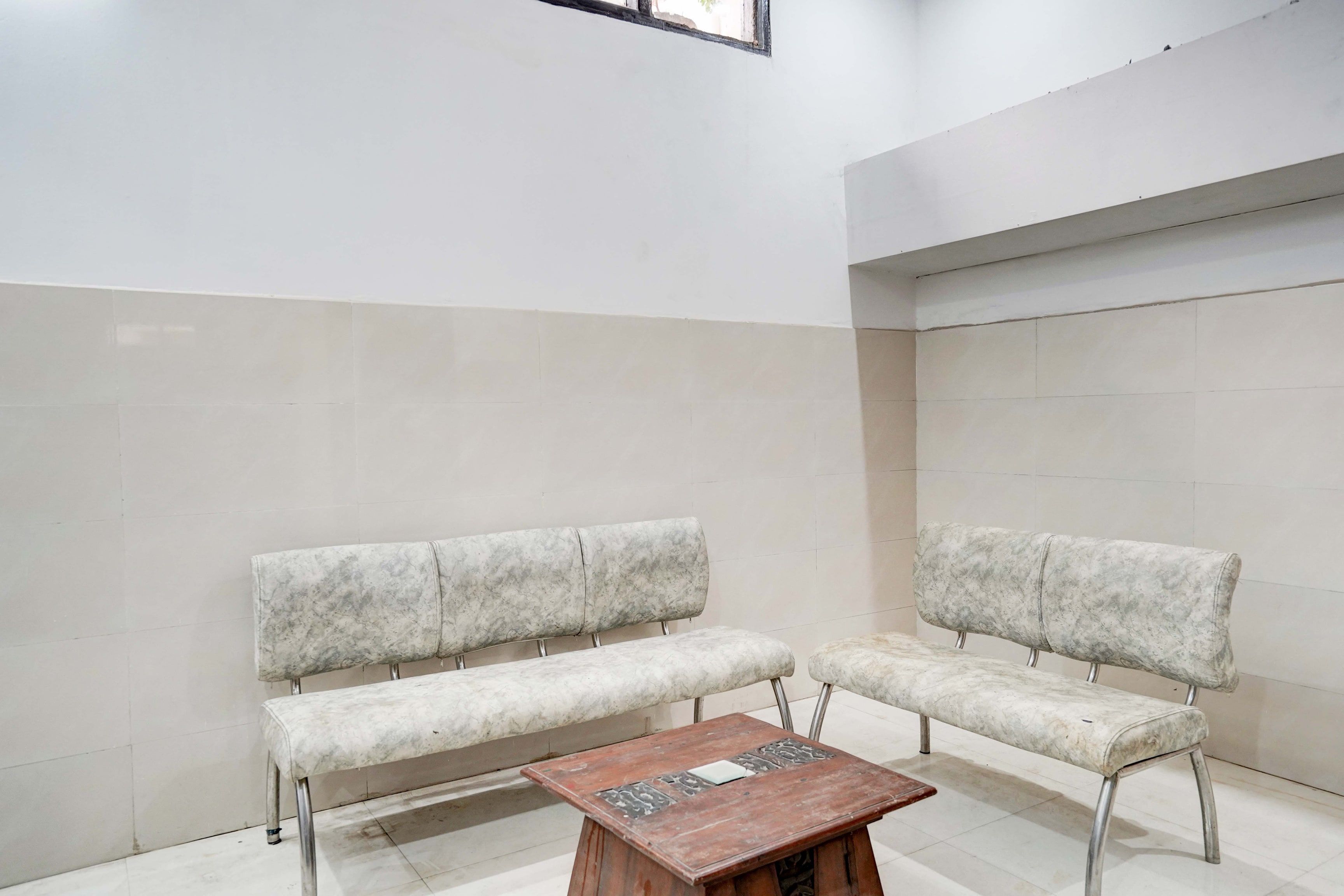 A room with two marble-patterned benches and a wooden table.