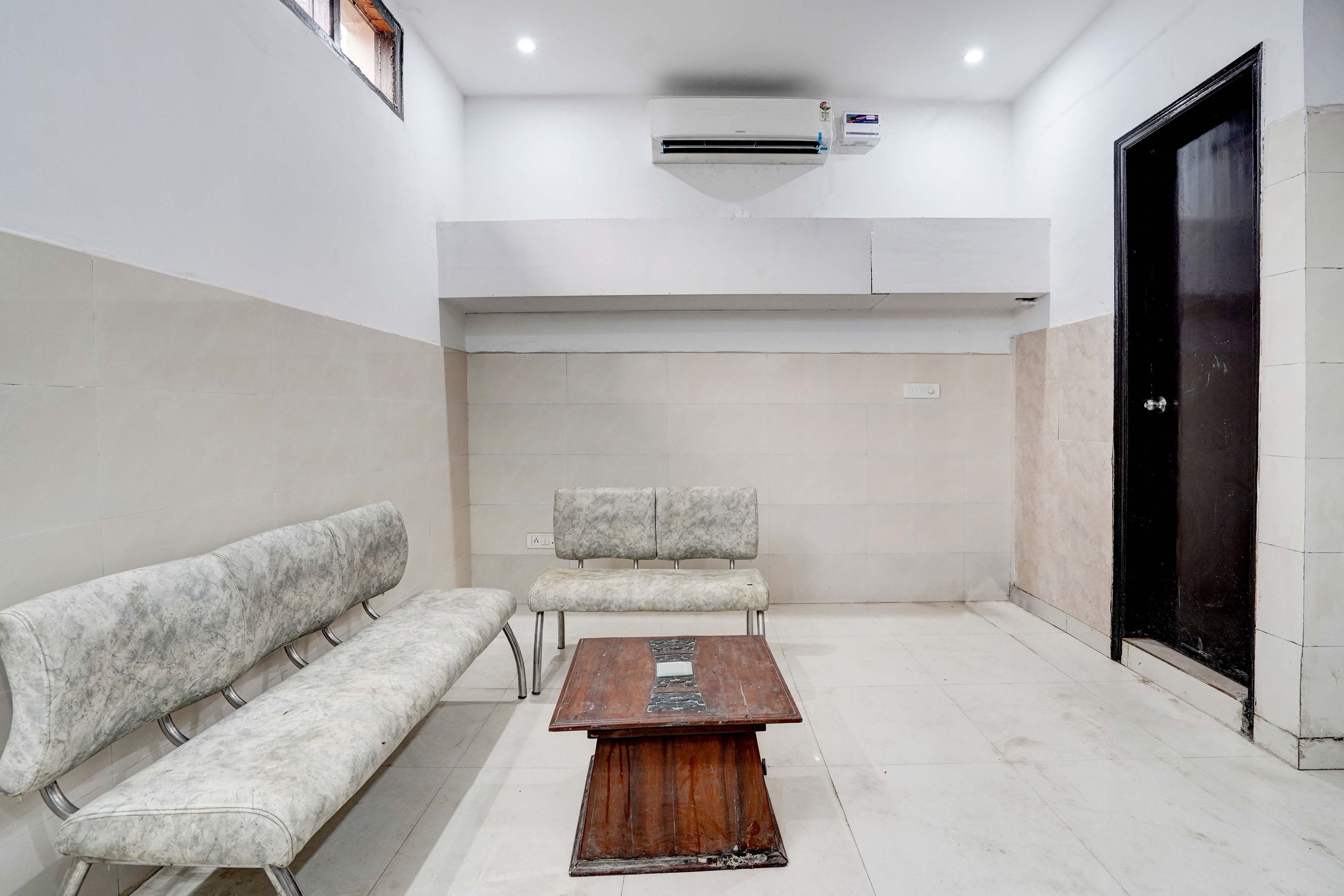 A waiting area with a bench, a small table, and a door.