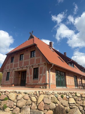 Ein traditionelles Fachwerkhäuschen mit steilem Dach, Steinmauerwerk und Schornstein.