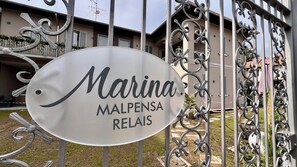 A sign with the name 'Marina' and 'Malpensa Relais' indicating a hotel or property.