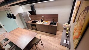 A modern kitchen with a wooden countertop, built-in oven, and a sink.