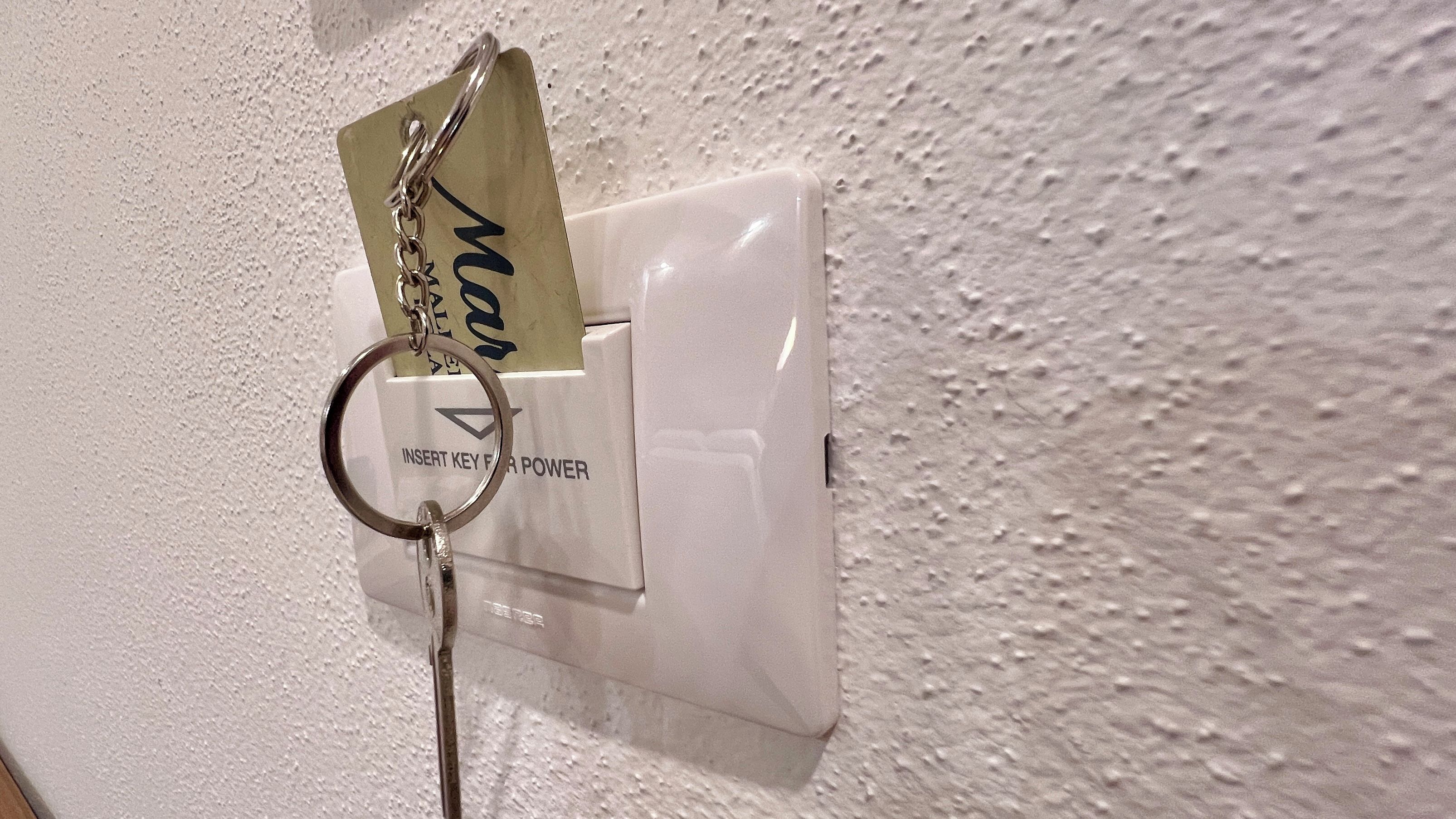 Un porte-clés avec une carte attachée à un anneau, insérée dans une serrure.