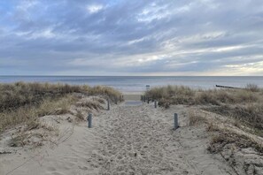 A sandy beach path leading to the sea with overcast skies. - Holiday home in Bansin with swimming pool (Bansin)