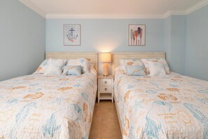 A double room with two beds, each with matching floral bedding and a nightstand between them. - #102 Seychelles 2/2 Oceanview Traffic Free Beach (Daytona Beach Shores)