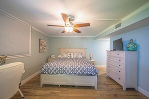 A bedroom with a bed, a dresser, a television, and a ceiling fan. - 1030 EastWinds S in Ponce Inlet, FL (Ponce Inlet)