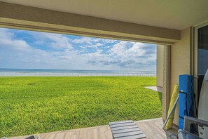 A balcony with a view of a grassy area and a beach. - 1030 EastWinds S in Ponce Inlet, FL (Ponce Inlet)