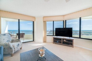 Ein Wohnzimmer mit großem Fernseher, einer Couch und einem Couchtisch.