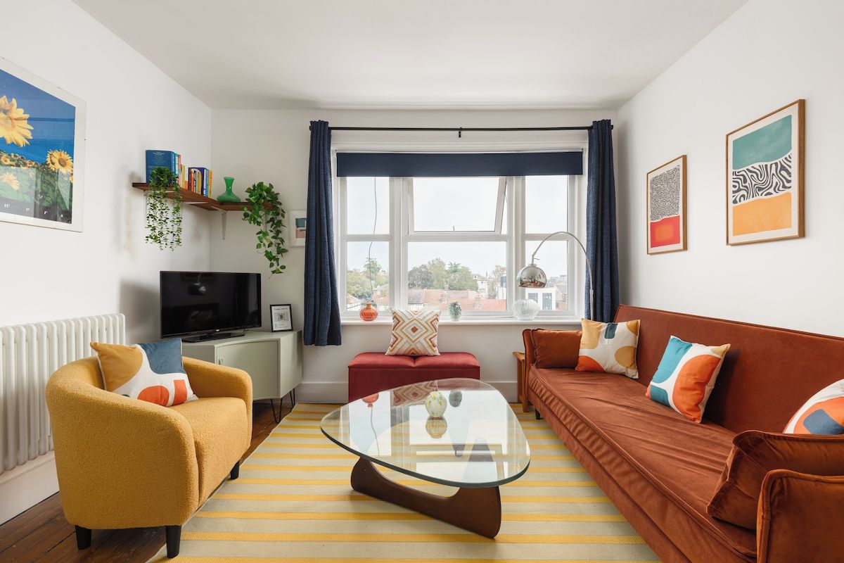 A living room with a sofa, armchair, and a glass coffee table.