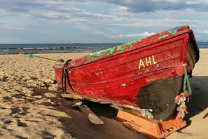 A red boat with the letters 'AHL' on a sandy beach. - House "Am Wald" Apt. 10 (Seebad Ahlbeck)