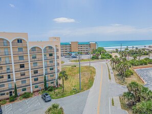 A multi-story hotel with balconies, a parking lot, and a view of the beach. - 201 Tidewater in Ponce Inlet, FL (Ponce Inlet)