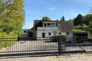 Ein Wohnhaus mit einem befahrbaren Grundstück, einer Garage und einem freistehenden Garagengebäude.