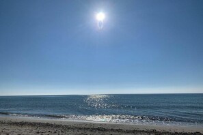 A beach with a clear sky and sunlight reflecting on the water. - "Holiday apartment at Kirr" (Zingst)
