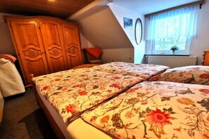 A bedroom with a bed, wooden wardrobe, and a window with curtains. - "Holiday apartment at Kirr" (Zingst)