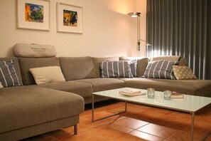 A living room with a sofa, a coffee table, and two framed artworks on the wall. - ||-----------------------Bodden Swallow------------------|| (Born am Darss)