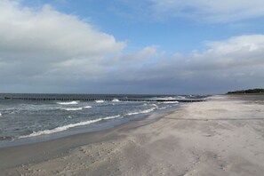 A beach with a wooden pier extending into the water. - ||-----------------------Bodden Swallow------------------|| (Born am Darss)