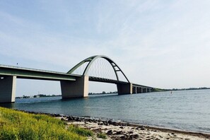 A large bridge spanning a river with a clear sky above. - Single-family house Sundseele No. 14 (Fehmarn)