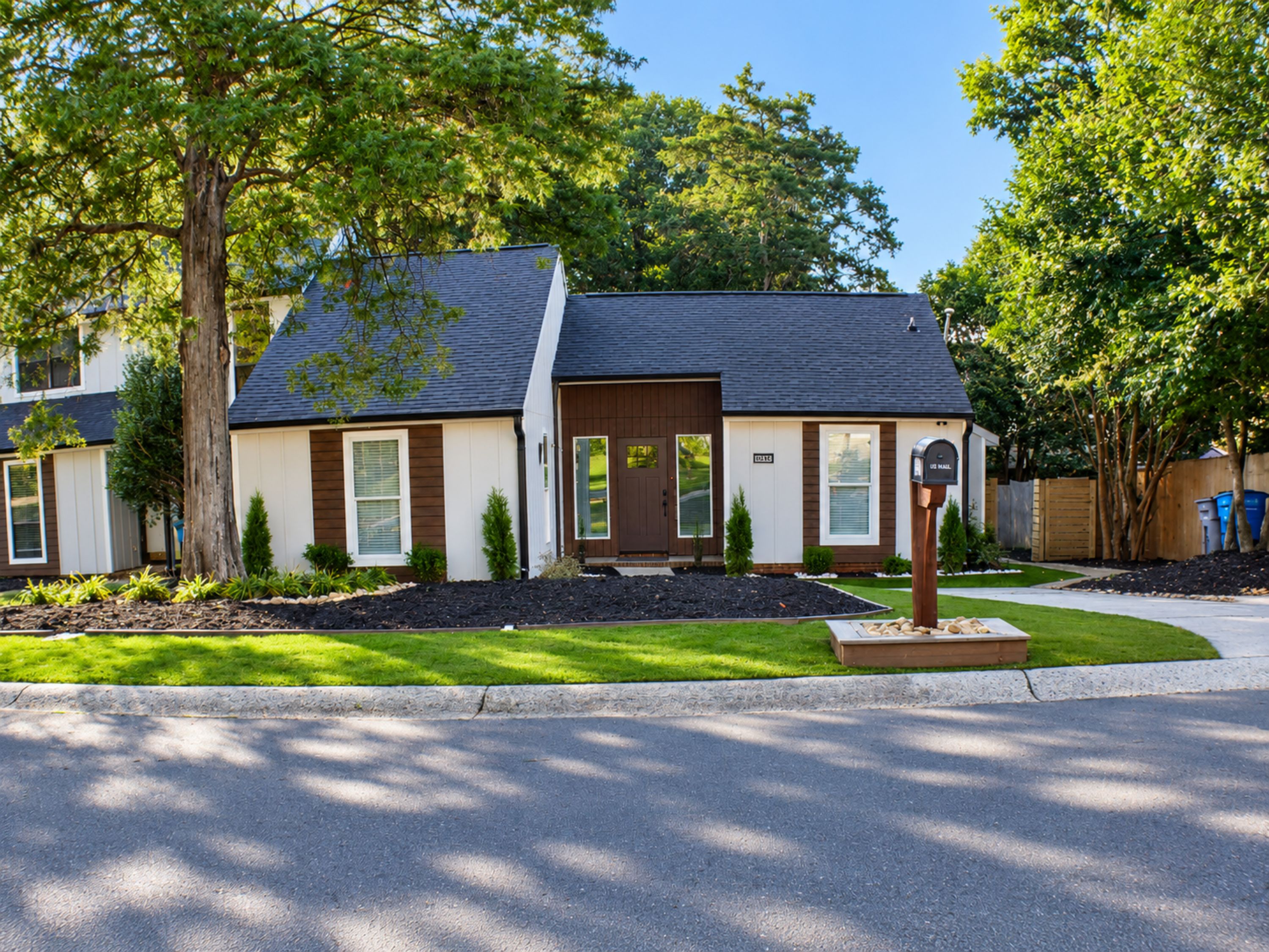 A two-story residential building with a front entrance, mailbox, and a well-maintained lawn.