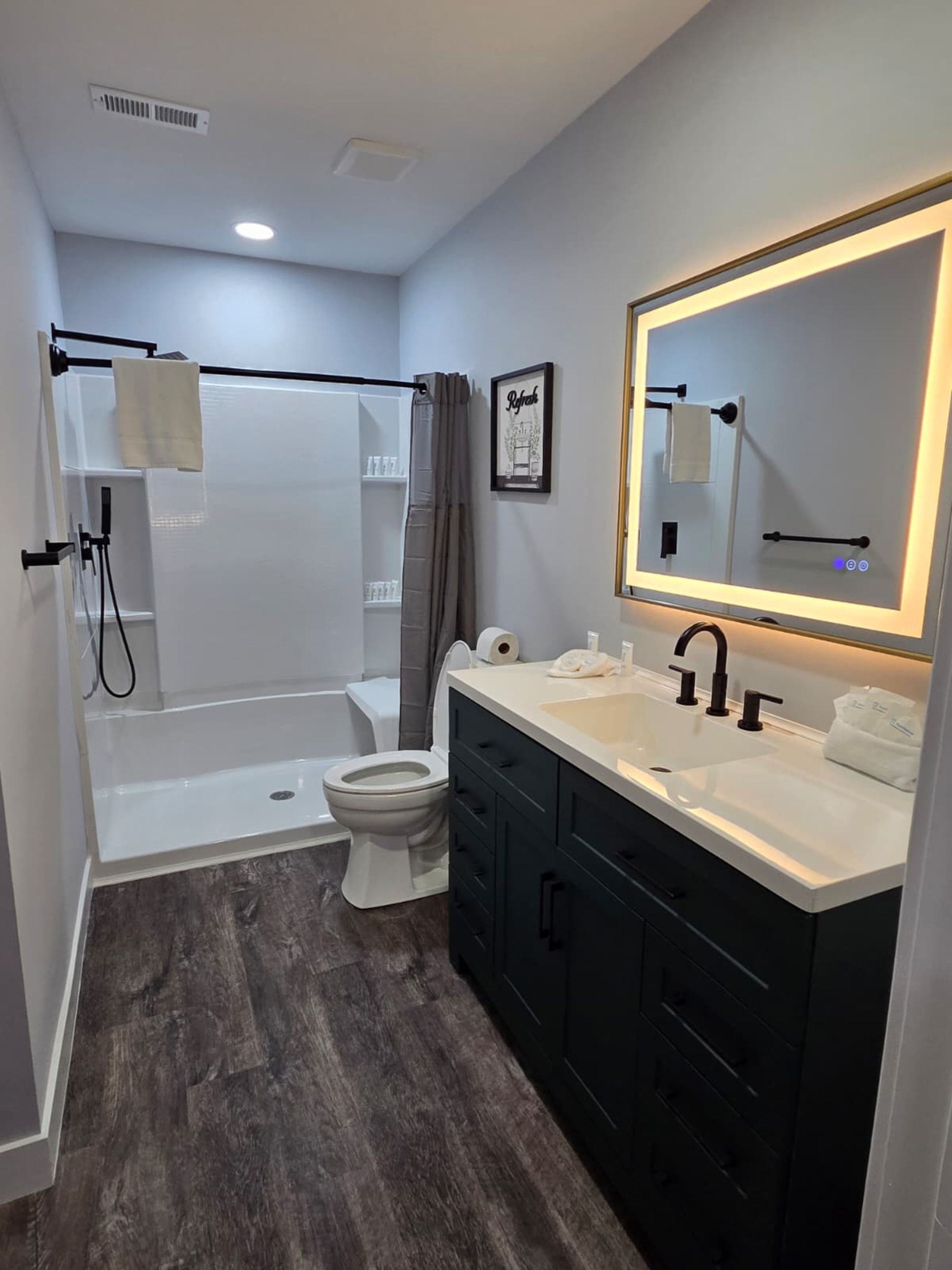 A modern bathroom with a shower, toilet, and vanity.