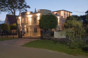 A large, multi-story building with a circular section, surrounded by a black metal fence. - Holiday apartment with 1 bedroom (Dierhagen)