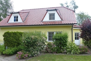A two-story house with a red-tiled roof, a small attic window, and a front door. - Beach butterfly Zingst (Zingst  (Fischland Darß))