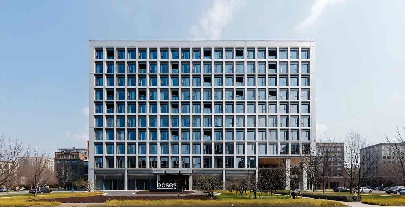 A modern multi-story building with a grid of windows and a flat roof.