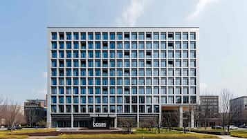 Un edificio moderno a più piani con una griglia di finestre e un tetto piatto.