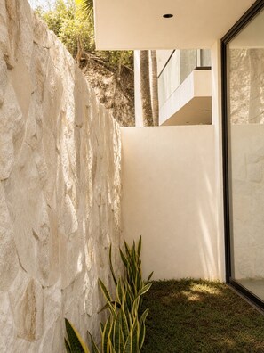 Un bâtiment moderne avec un mur en pierre et une porte en verre.