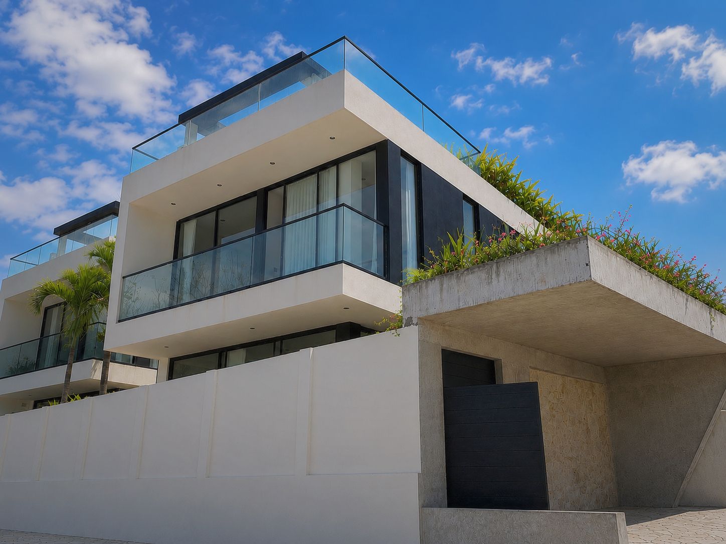 Um edifício moderno de dois andares, com varanda de vidro e base de concreto.