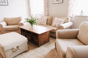 Un salon comprenant un canapé, une table basse et une table d’appoint.